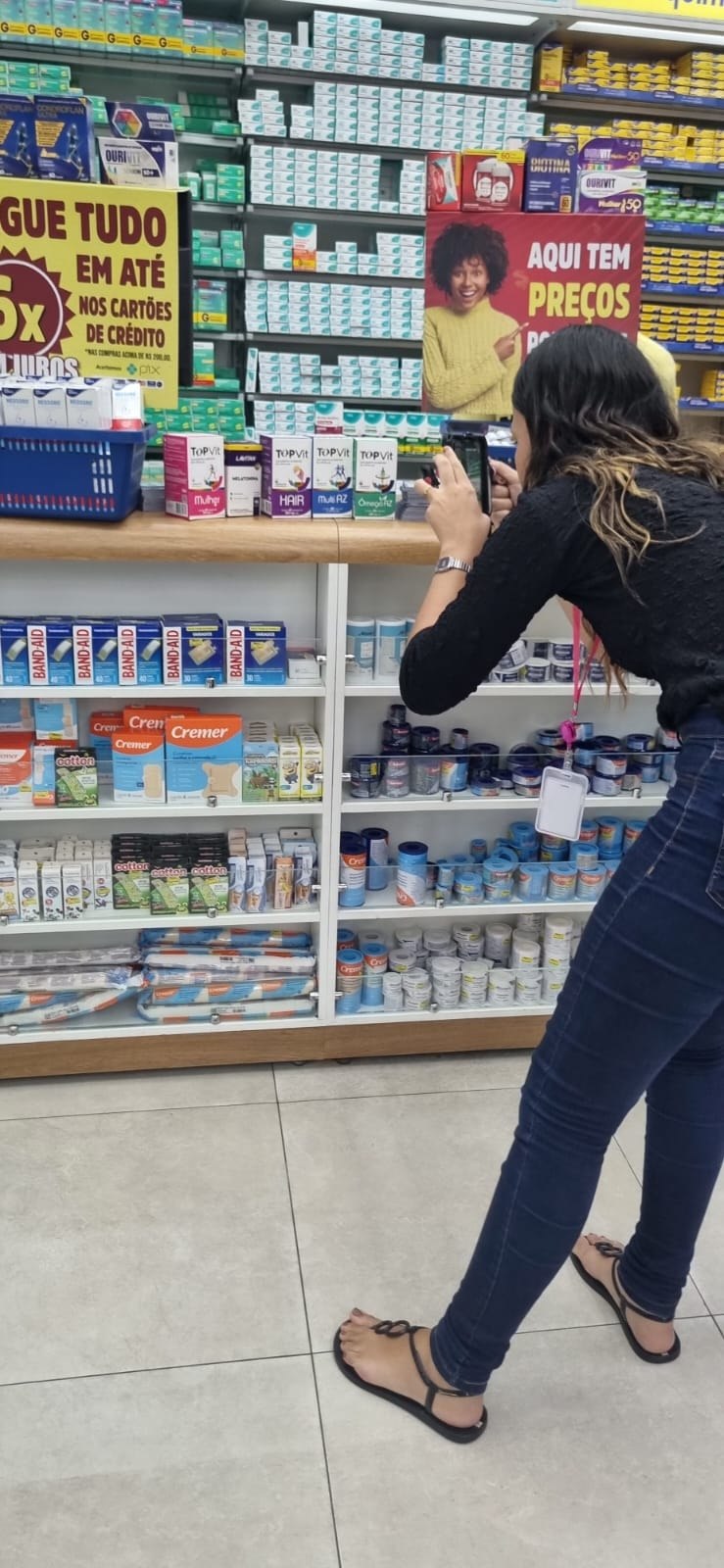 Videomaker gravando funcionário entre produtos em comércio local